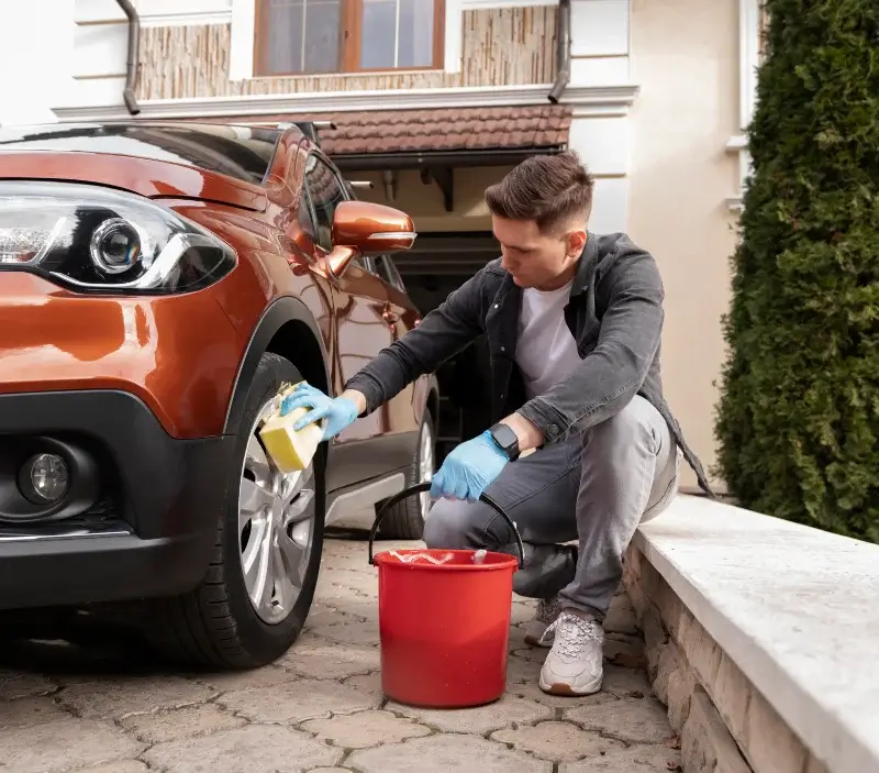 Lavage auto à domicile Plourin-lès-Morlaix : professionnel intervenant sur un véhicule
